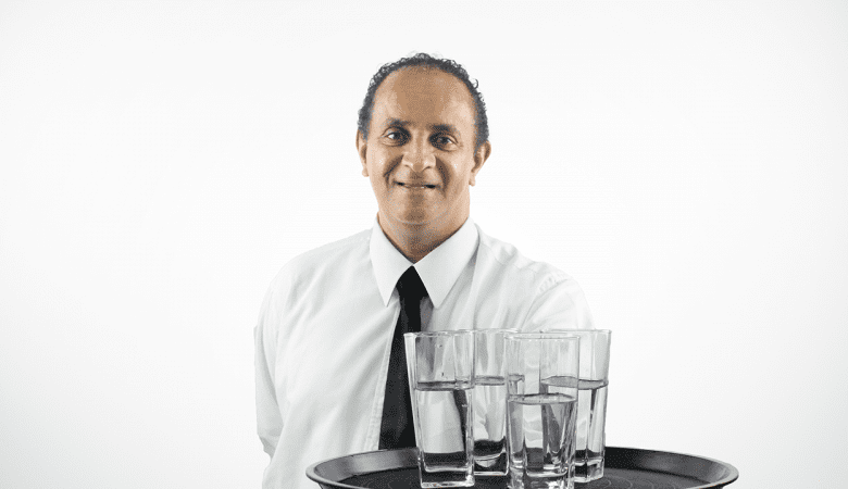 homem segurando uma bandeja com quatro copos com água