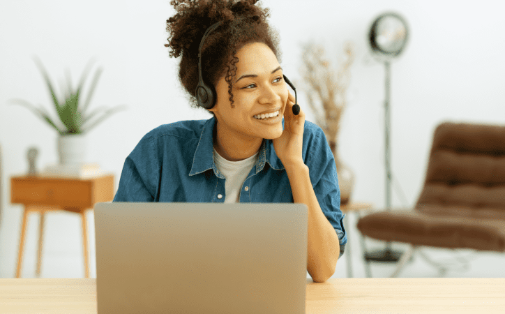 Mulher com fone de ouvido e microfone na frente de um notebook