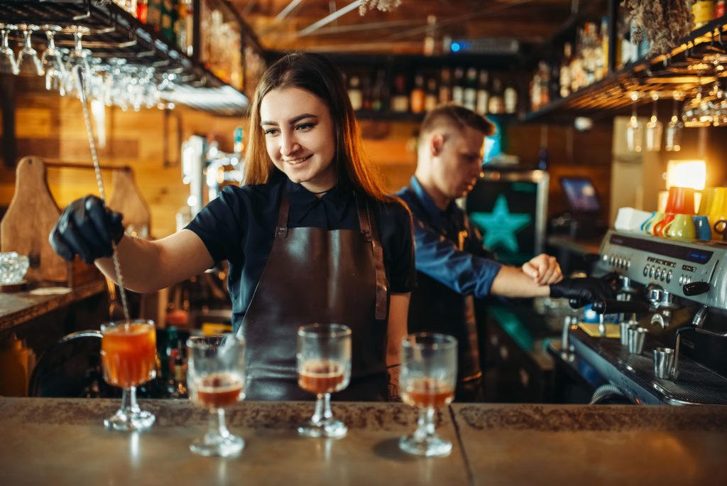 Barman e Bartender trabalhando juntos realizando drinks